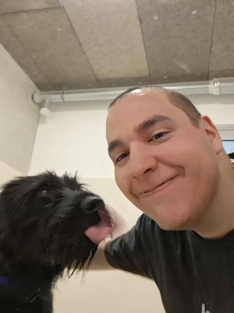 Un grand chien noir à poil long, langue pendante, à côté de Tonton Canin